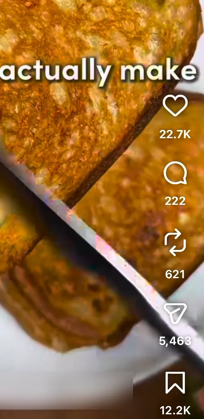 An Instagram reel of a grilled cheese sandwich being sliced, with the column of buttons on the right: like, comment, repost, share (the paper plane) and save
